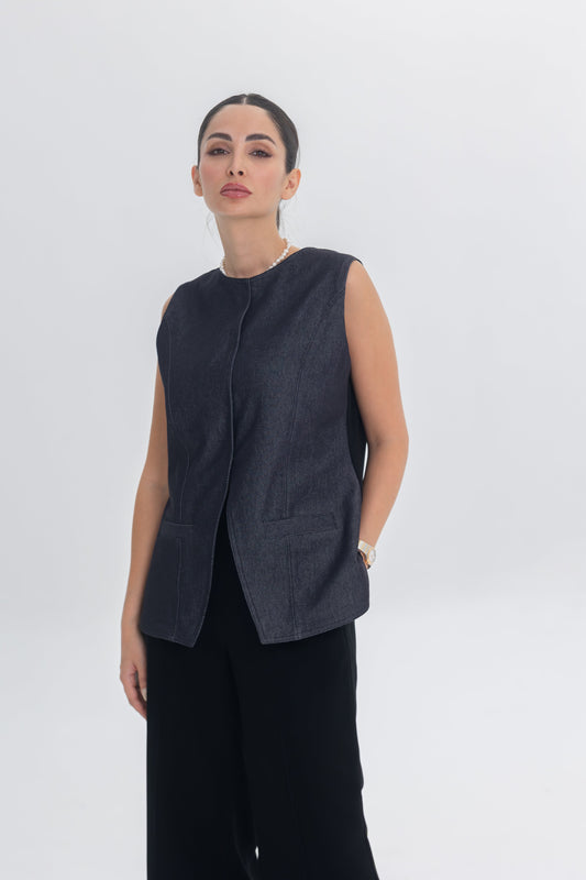 Woman wearing True Bleu sleeveless denim top and black crepe pants in a minimalist studio setting