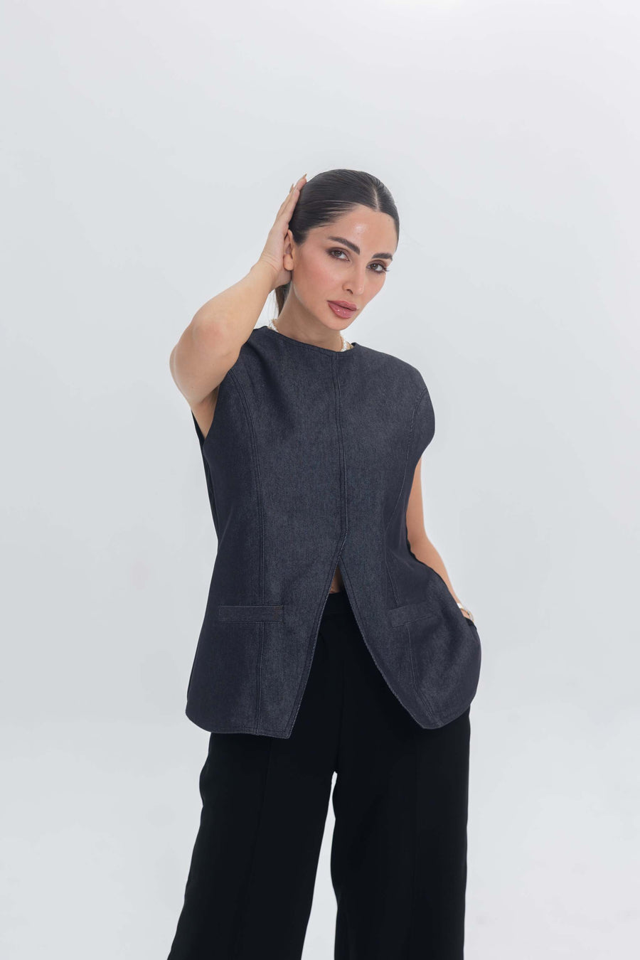 Woman wearing True Bleu denim sleeveless top with black crepe pants in a modern minimalist style