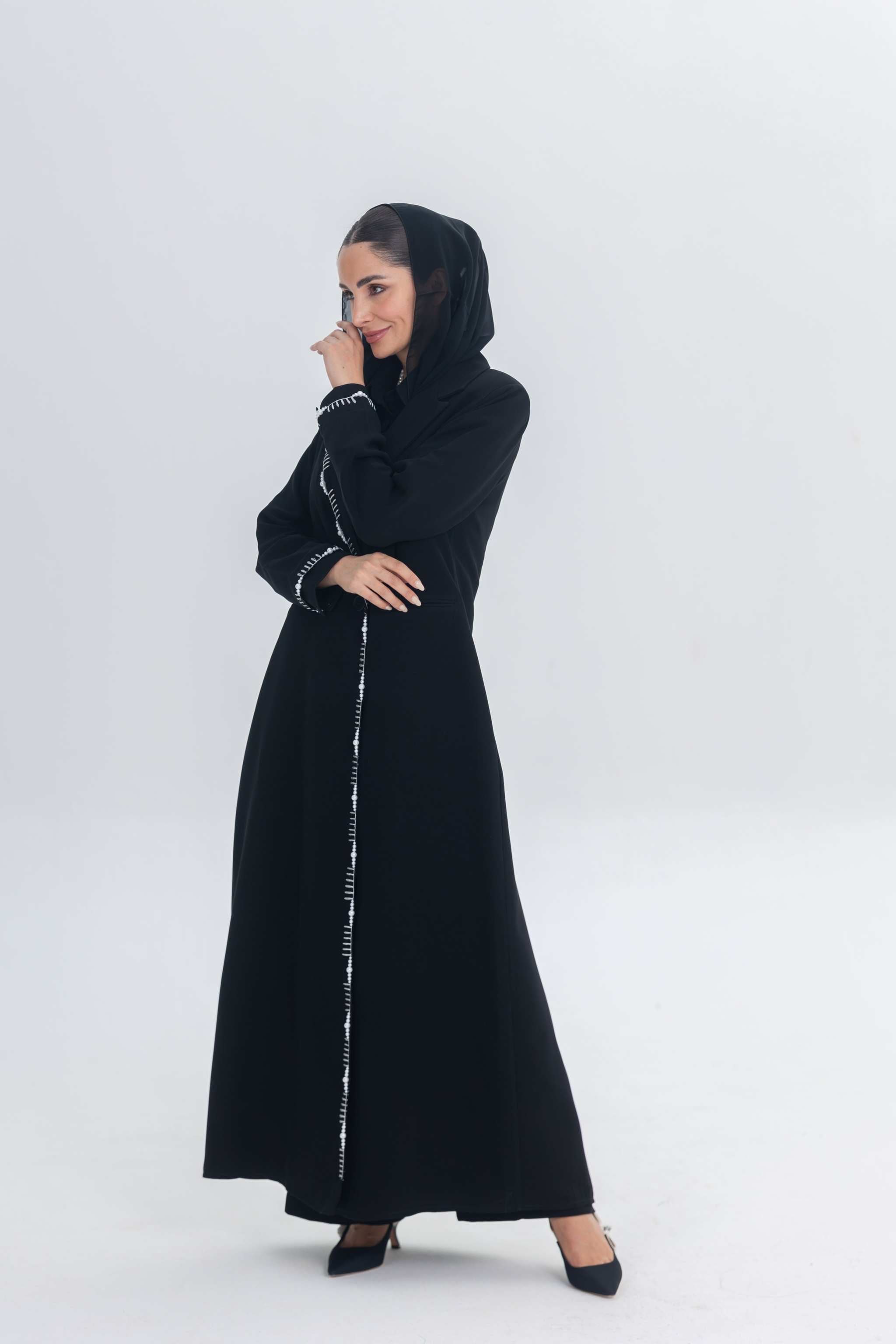 Elegant black crepe blazer abaya with white pearl and bead embroidery, tailored silhouette on woman with hijab