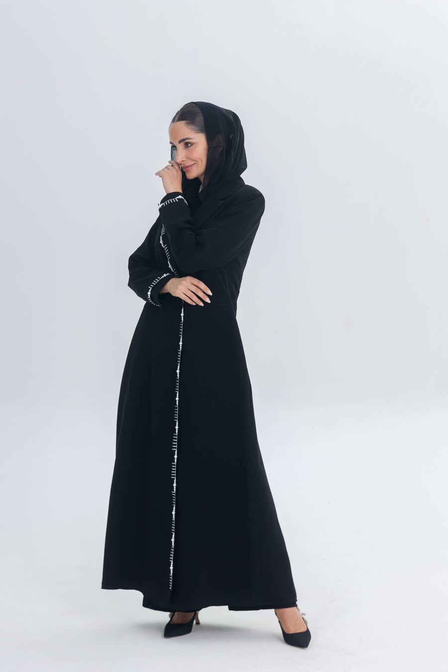 Elegant black crepe blazer abaya with white pearl and bead embroidery, tailored silhouette on woman with hijab