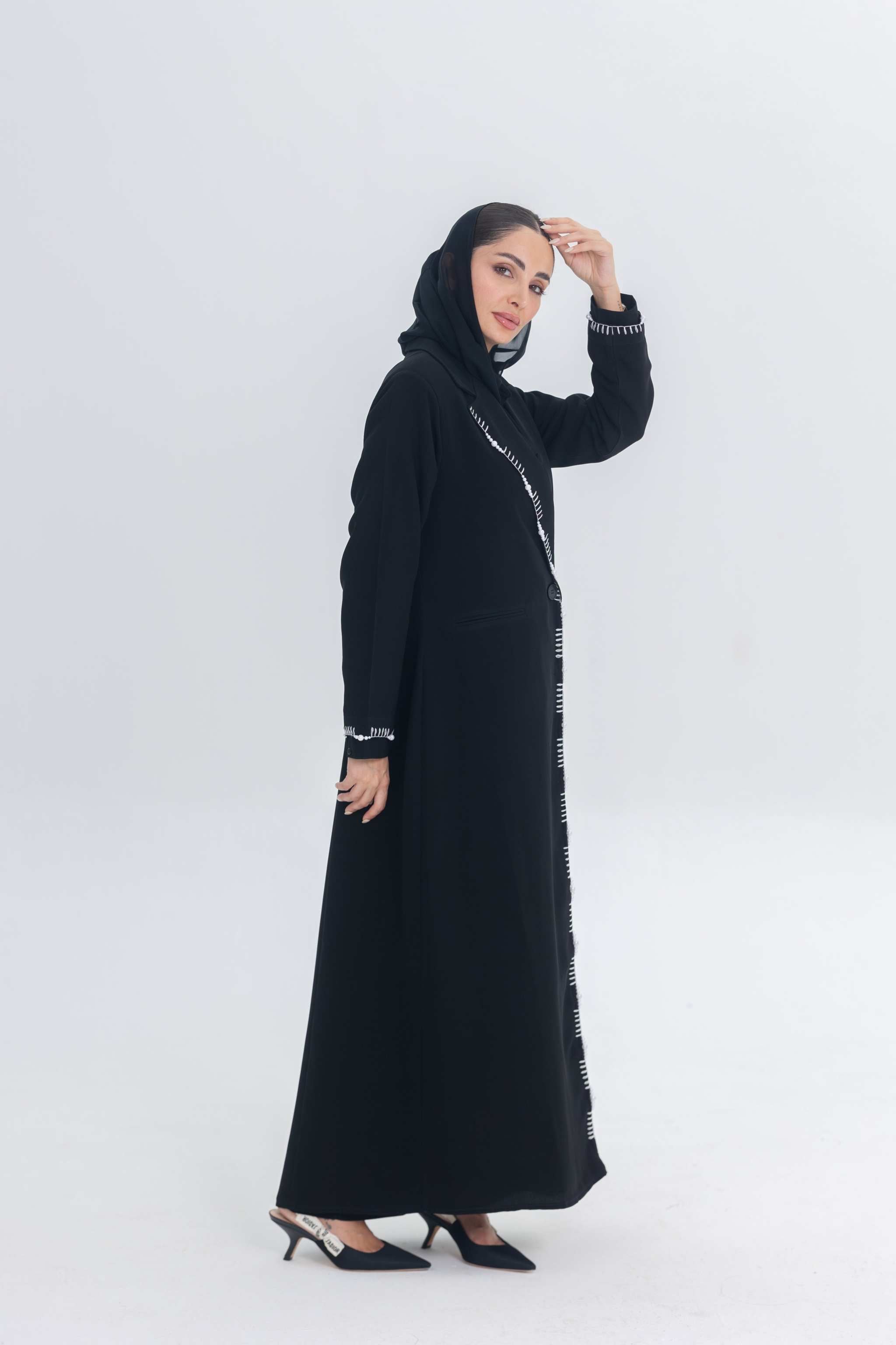 Black crepe blazer abaya with white pearl and bead embroidery on tailored silhouette worn by woman in hijab
