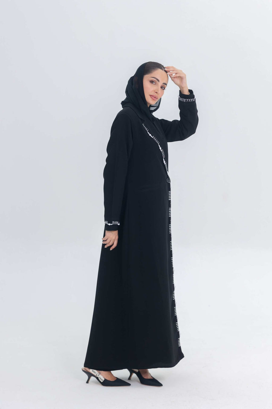 Black crepe blazer abaya with white pearl and bead embroidery on tailored silhouette worn by woman in hijab