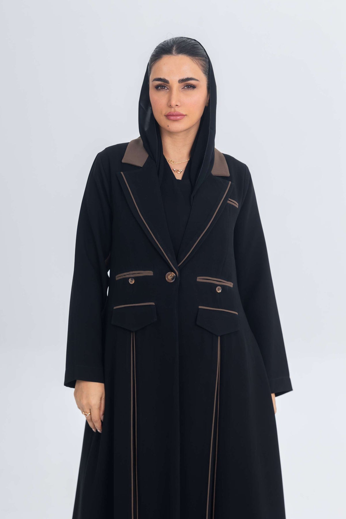 Black crepe blazer abaya with brown trims and detailing, featuring a sleek tailored silhouette and flowing fabric.