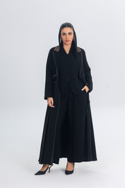Woman wearing a black Chestnut Glow Abaya with brown brim details in a sleek blazer silhouette.
