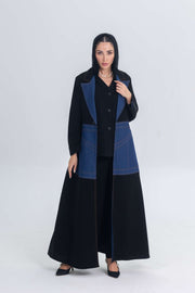 Black crepe abaya with denim panels and structured modern design worn by a woman