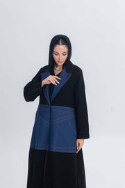 Woman wearing black crepe abaya with denim panels and collar, combining traditional elegance with modern style