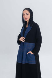 Woman wearing a black crepe abaya with blue denim panels and hood, featuring a modern and elegant design.