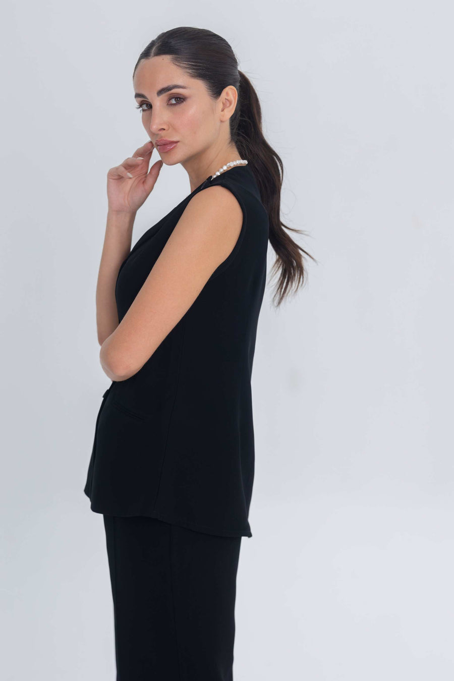 Woman wearing a plain black sleeveless crepe inner set for modest layering