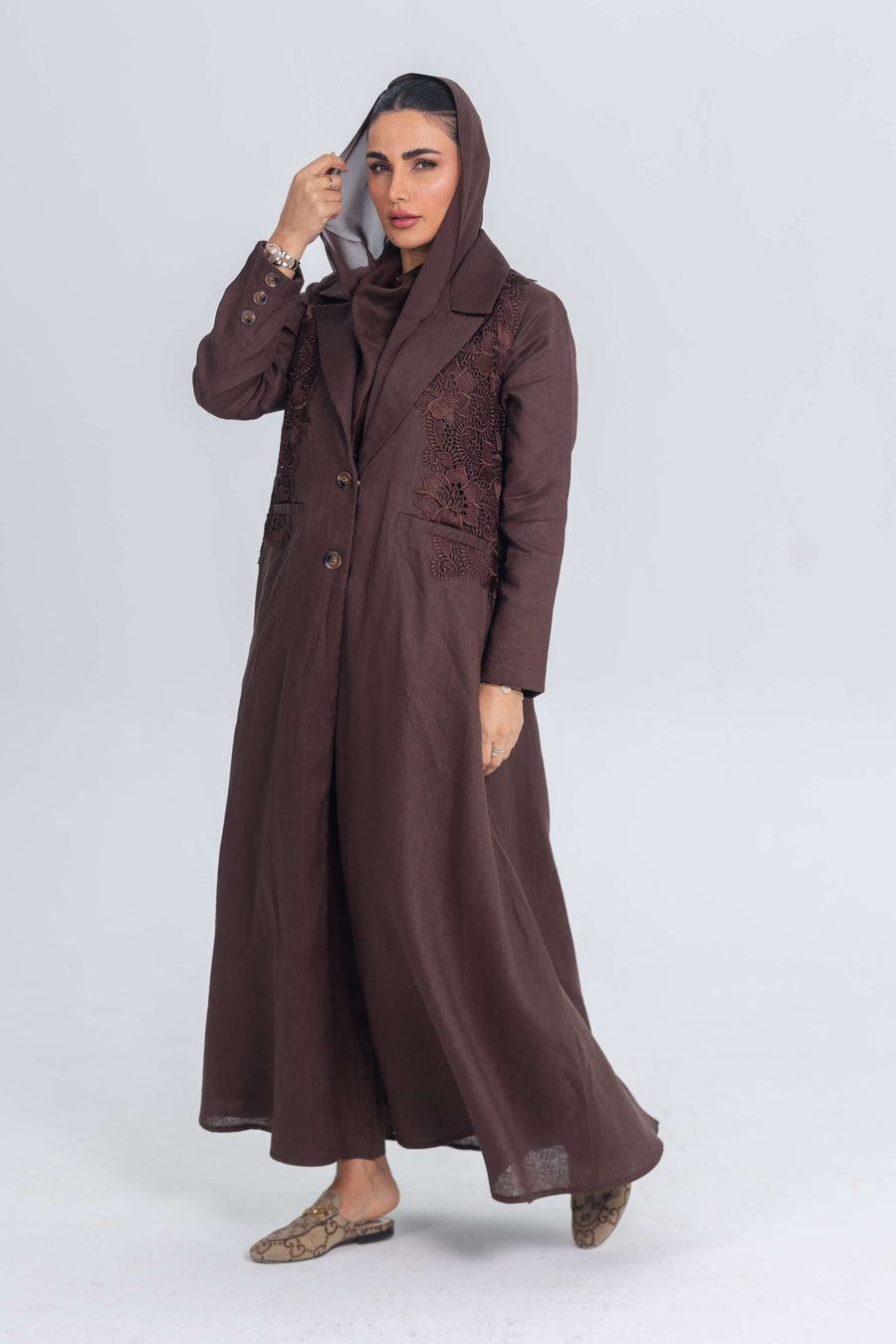Woman wearing brown linen abaya with blazer collar and floral lace embroidery patches