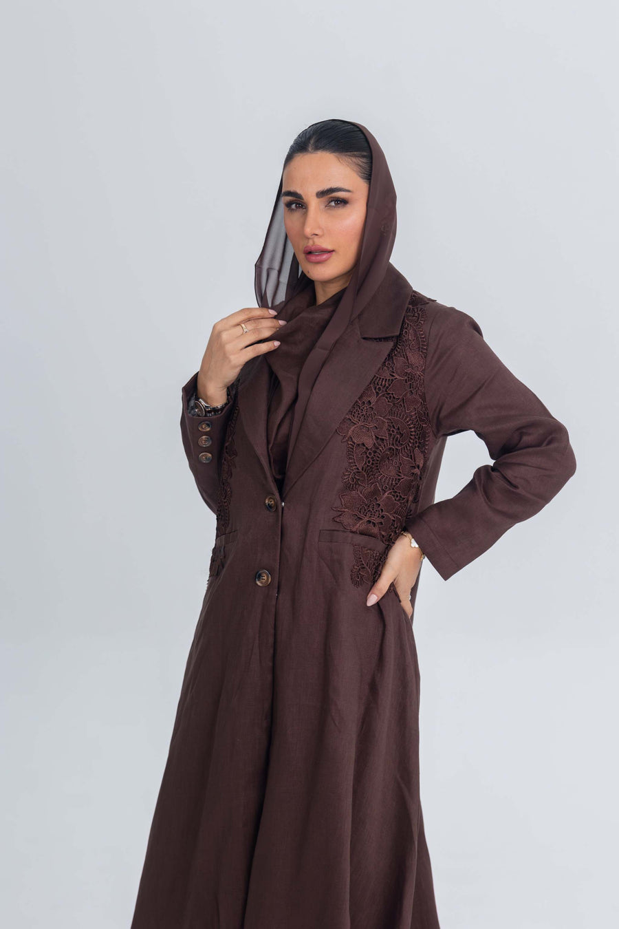 Woman wearing brown linen abaya with blazer collar and floral lace embroidery patches