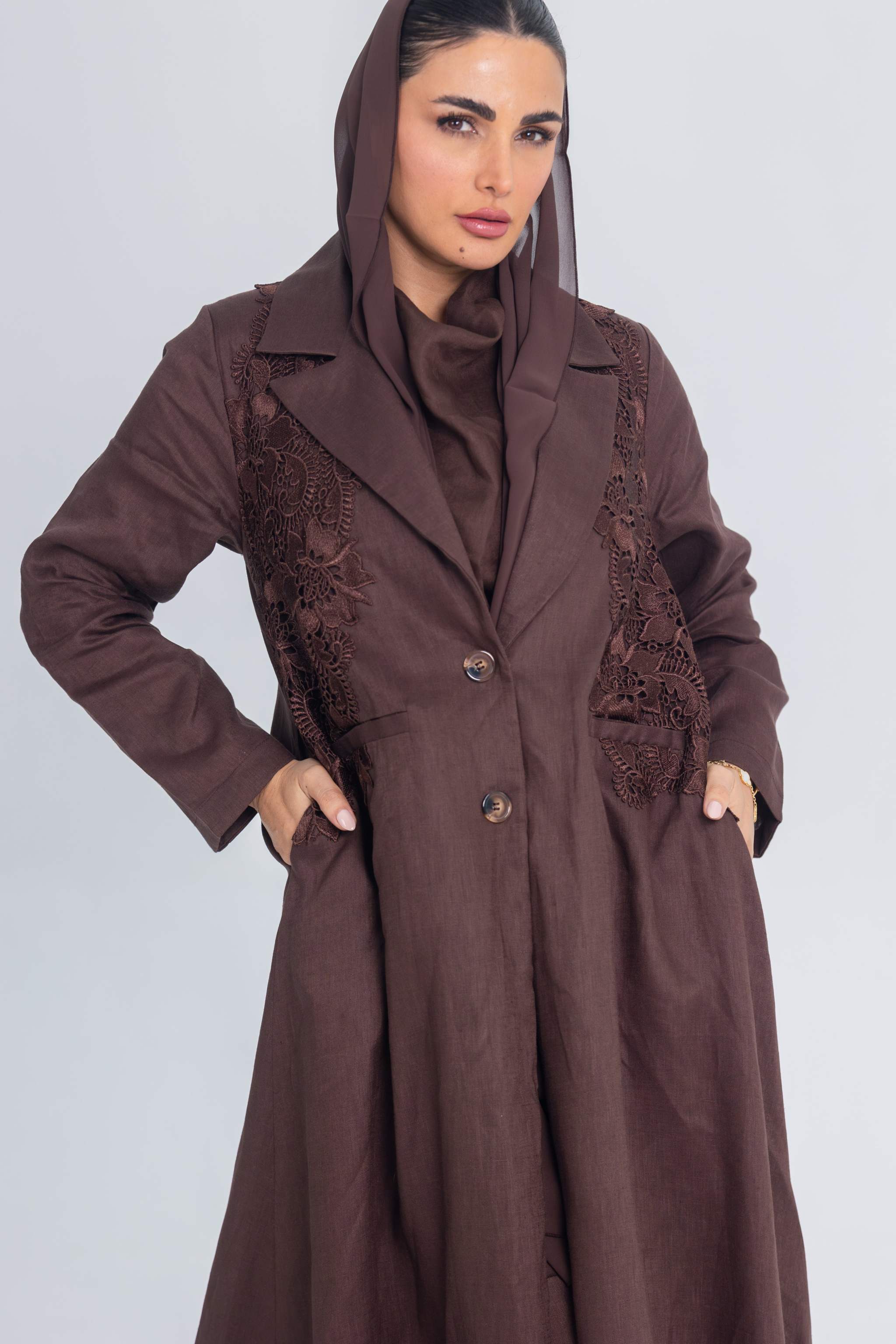Woman wearing brown linen Sandstone Stitch abaya with floral lace embroidery and blazer collar