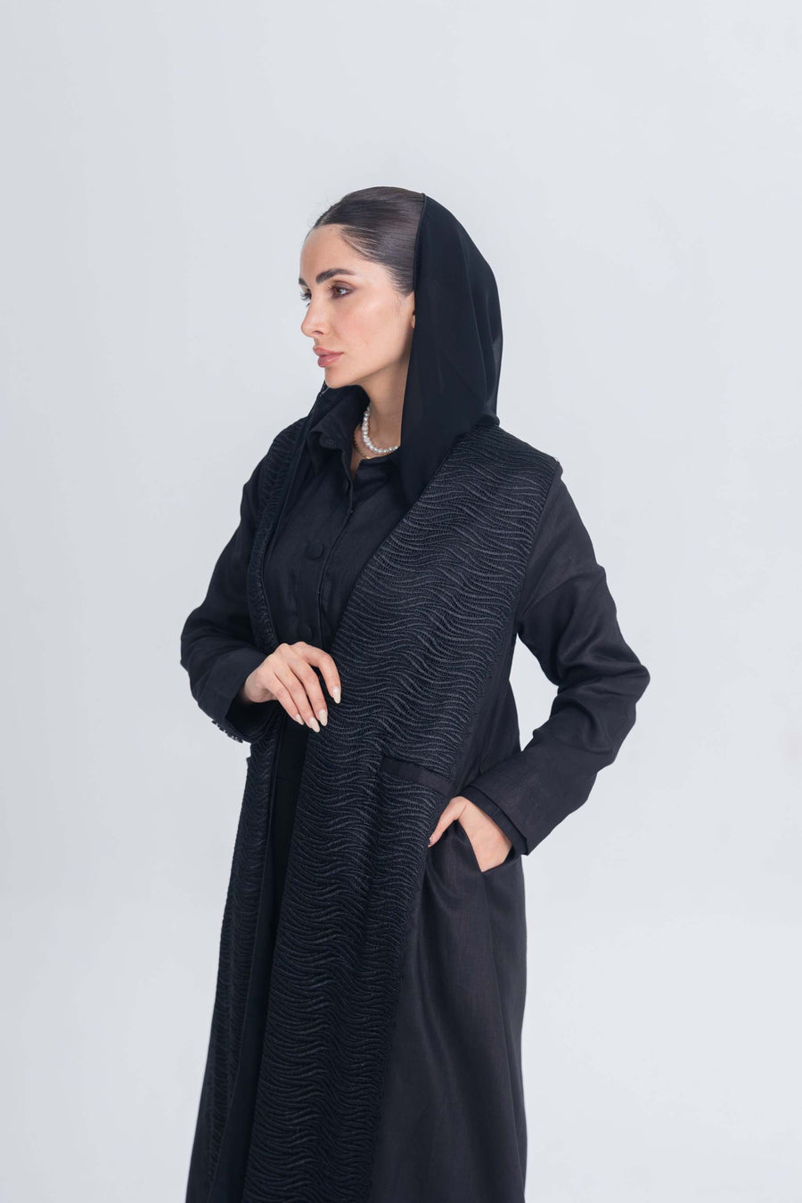 Black linen abaya with textured fabric detail and hood, elegant modest wear for daily and professional use