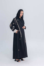 Black luxury linen abaya with beige circular embroidery and structured flowing design worn by woman