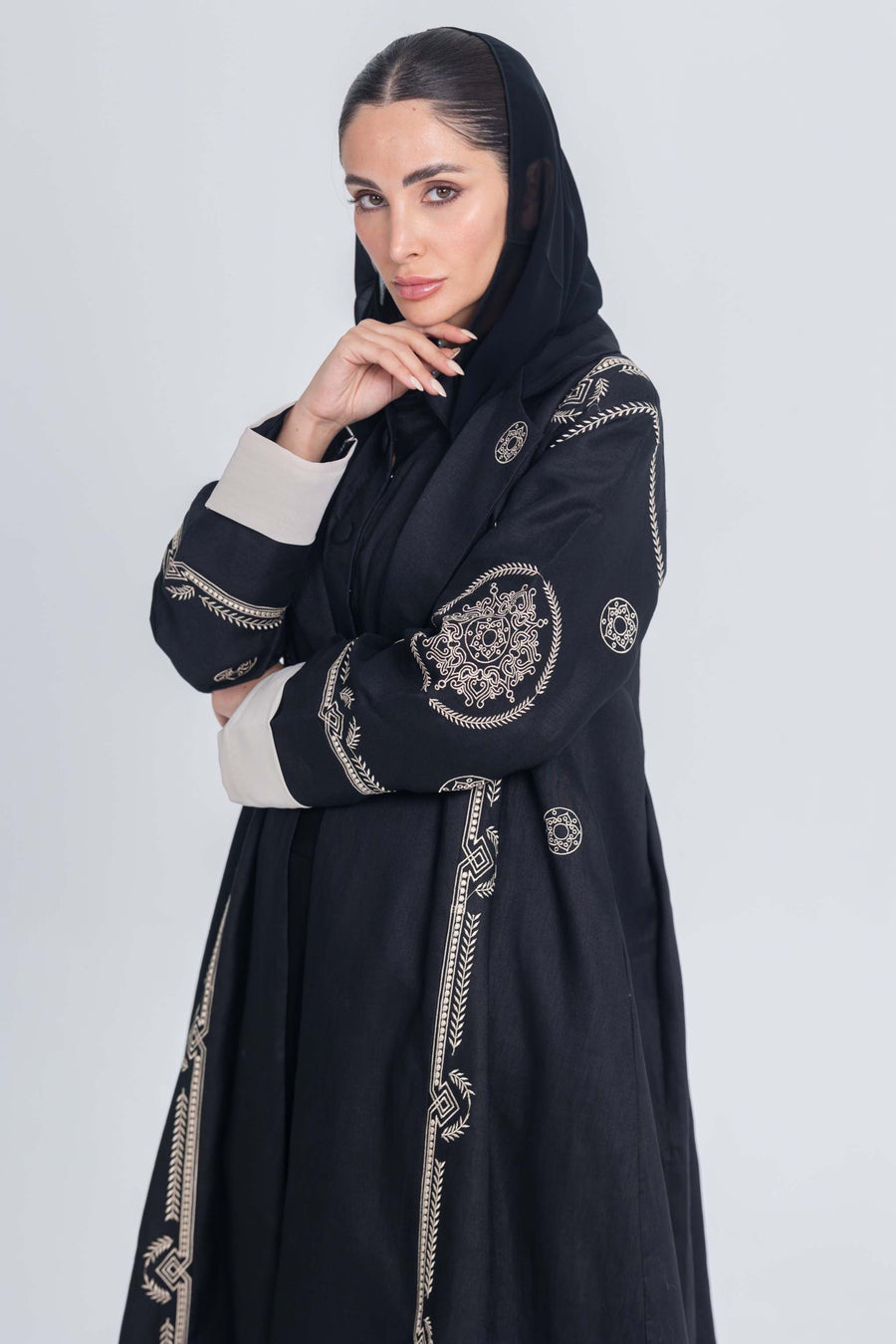 Black linen abaya with intricate beige circular embroidery and beige cuffs, lightweight and elegant design for modern wear