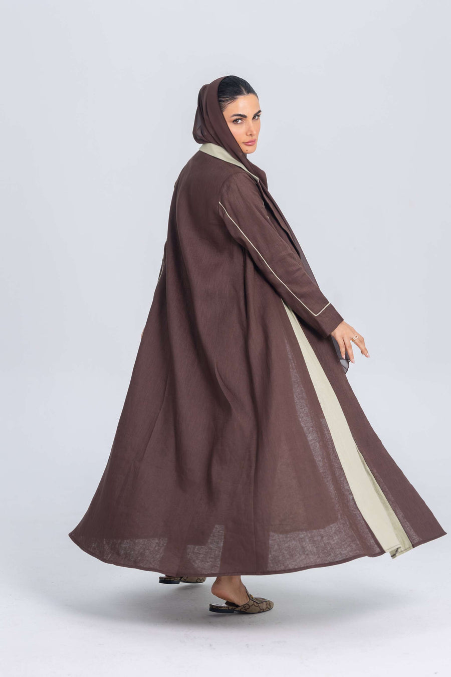 Brown linen abaya with soft mint green panels and refined detailing, showcasing a modern and timeless design.