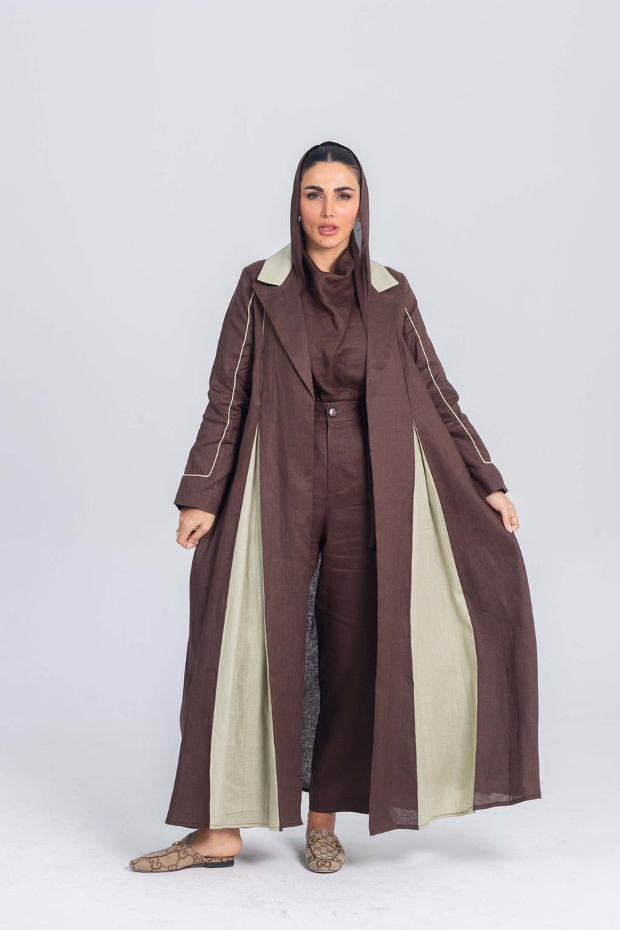 Woman wearing Mint Mocha brown linen abaya with soft mint green panels and fine detailing, styled with tailored clean lines and subtle elegance.