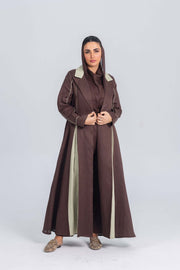 Woman wearing a brown linen abaya with soft mint green panels and clean lines, styled with modest elegance.