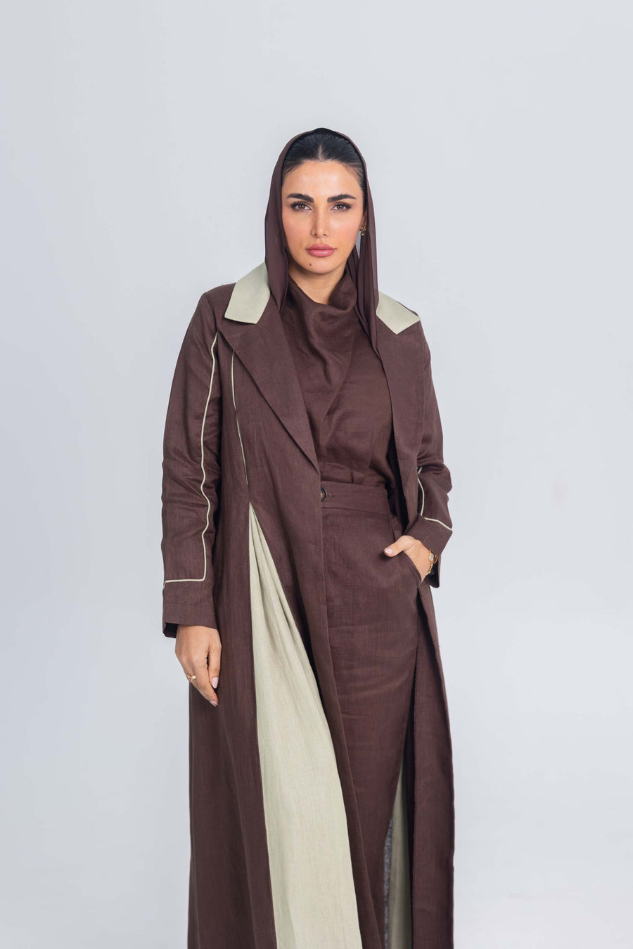 Woman wearing a Mint Mocha brown linen abaya with soft mint green linen panels and fine detailing, featuring clean lines and refined brims.