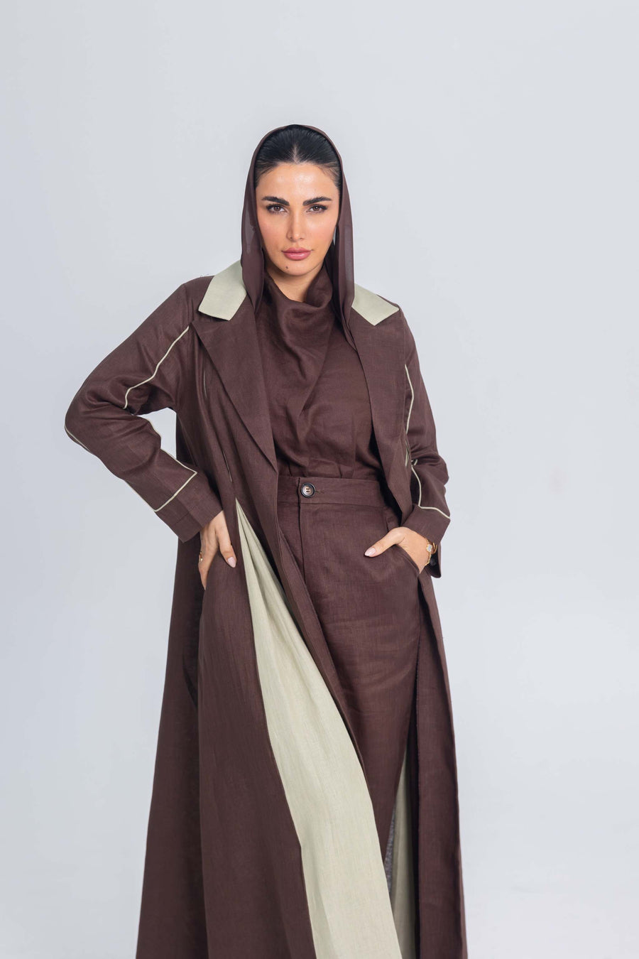 Woman wearing a Mint Mocha brown linen abaya with soft mint green panels and refined detailing.