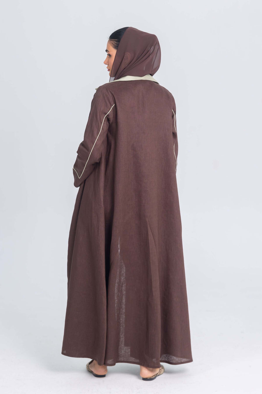 Brown linen abaya with mint green panels and fine detailing, back view showing modest design and clean lines.