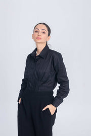 Woman wearing black Essence Folds shirt with pleated chest detail and long sleeves