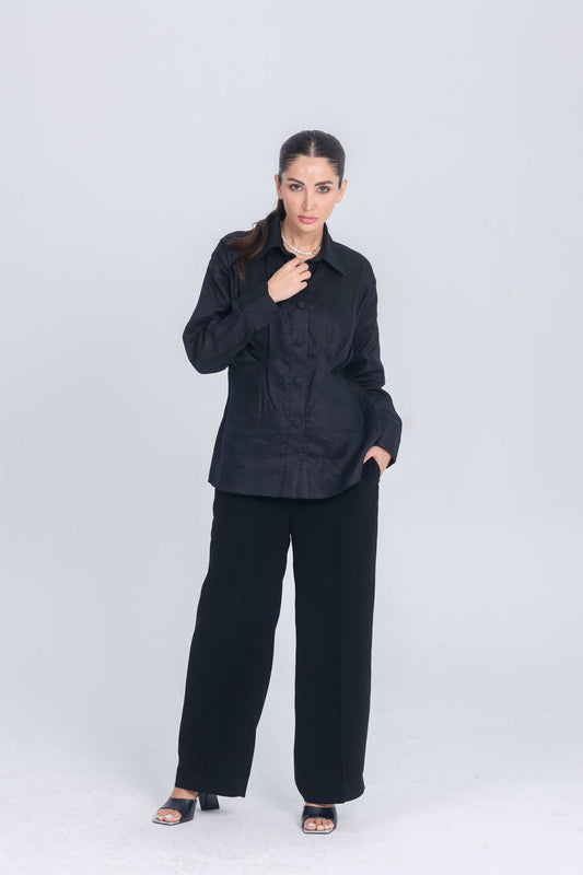 Woman wearing Essence Folds black shirt with chest pleat detail and black wide-leg pants