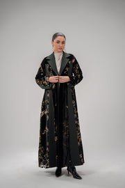 Woman wearing Evergreen floral velvet and crepe abaya with blazer cut and green lapel collar
