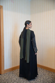 Back view of a woman wearing a Classic Straight-Cut Black Abaya with floral embroidered sleeves and olive green trim, featuring a loose fit and front buttons.