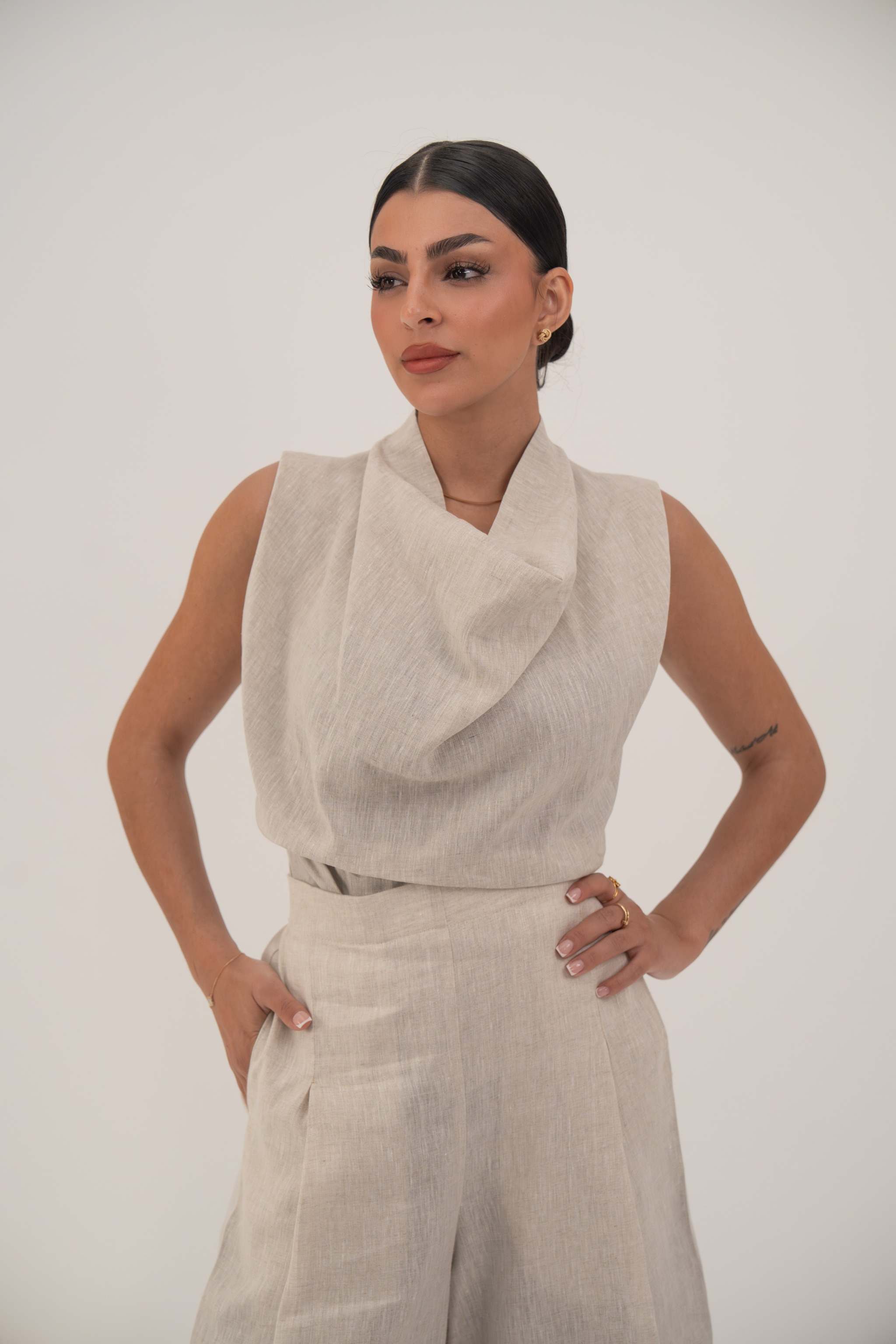 woman wearing linen beige wide leg pants with side pockets and sleeveless top