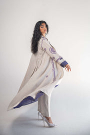 Soft beige linen blazer abaya with intricate purple geometric and circular embroidery, classic collar, pleated back, and delicate purple chiffon inner layer.