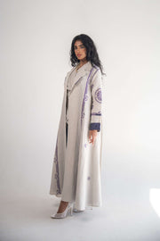 Woman wearing beige linen blazer abaya with purple geometric embroidery and chiffon inner layer