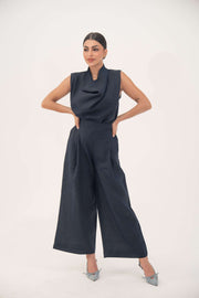 Woman wearing indigo wide leg high-waisted linen pants with front pleats and hidden pockets