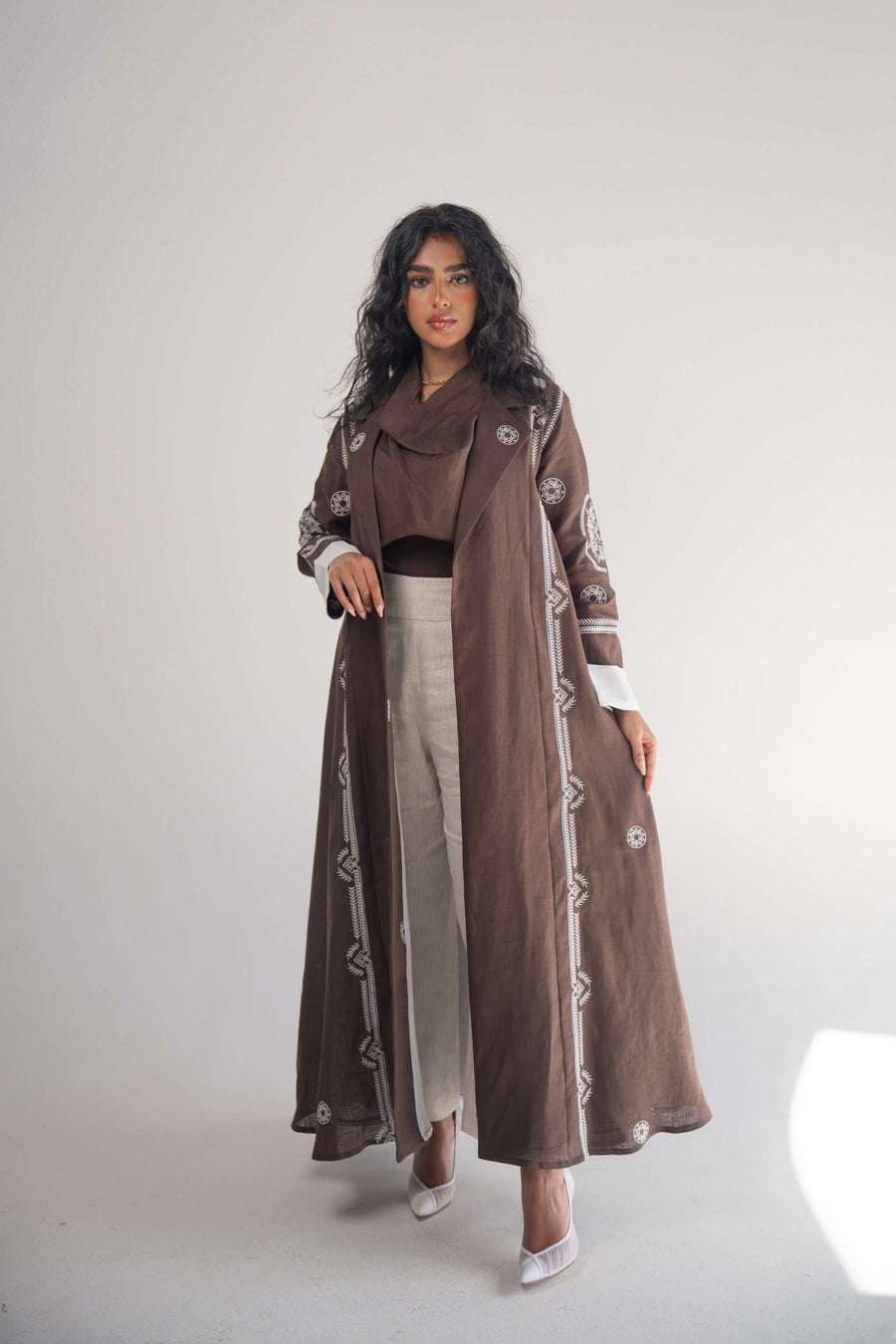 Woman wearing cocoa linen blazer abaya with white geometric embroidery and chiffon lining