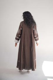 Back view of a cocoa linen blazer abaya with white circular and geometric embroidery on sleeves, sides, and back, featuring subtle pleats and white chiffon lining.
