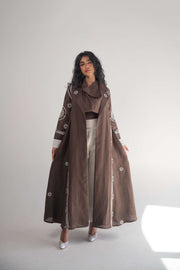 Brown linen blazer abaya with white circular and geometric embroidery on sleeves and sides, featuring a classic lapel and pleated back, lined with soft white chiffon.