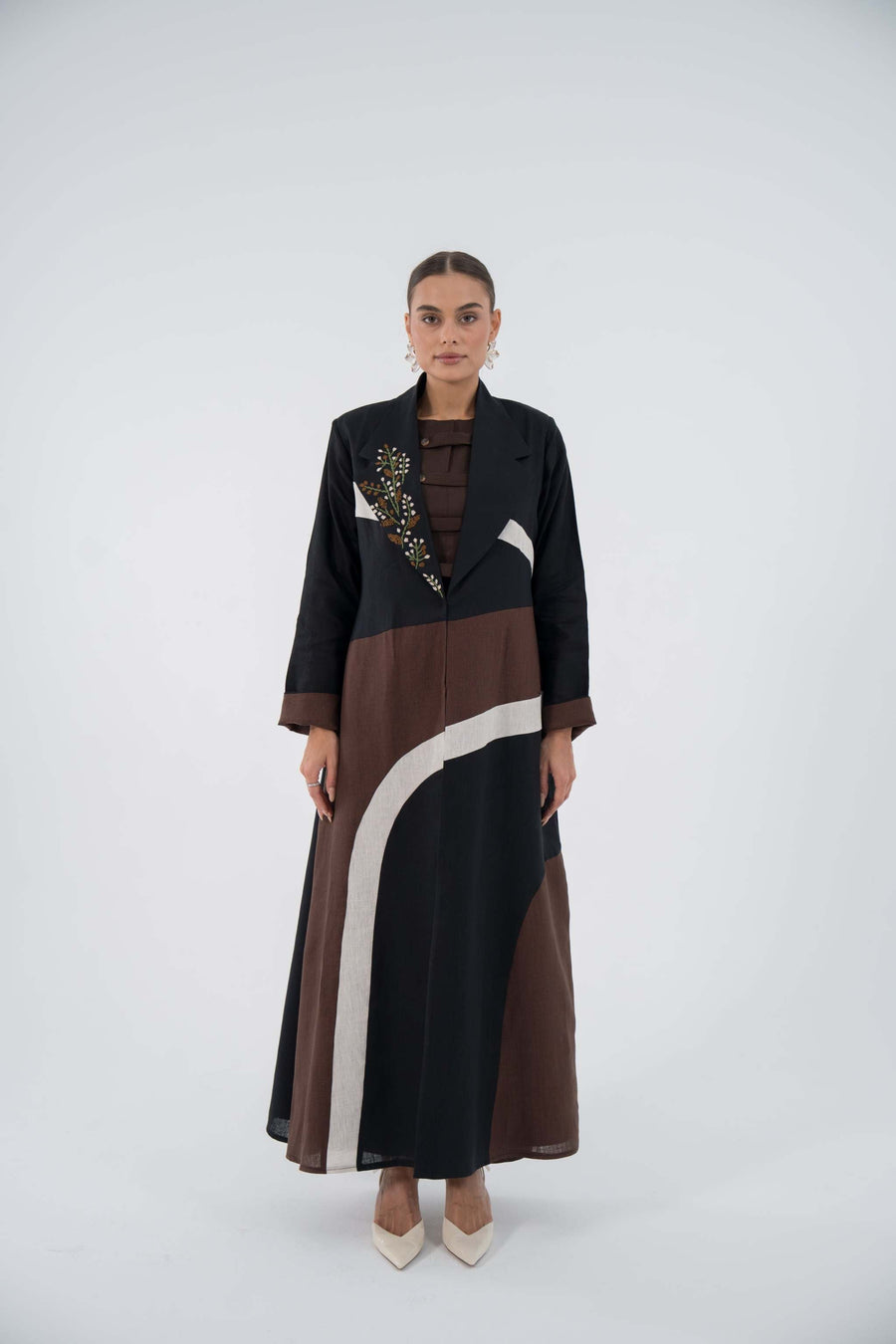 Curve Bloom Linen Abaya with black base, brown and white curved panels, floral embroidery, lightweight linen, flowing blazer style, relaxed fit.