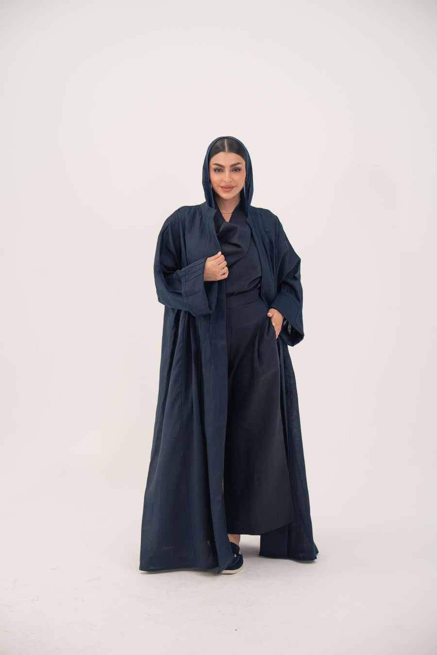 Woman wearing full-length open-front abaya navy blue linen with vertical stitched pleats