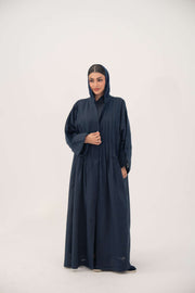 Woman wearing full-length open-front abaya navy blue linen with vertical stitched pleats