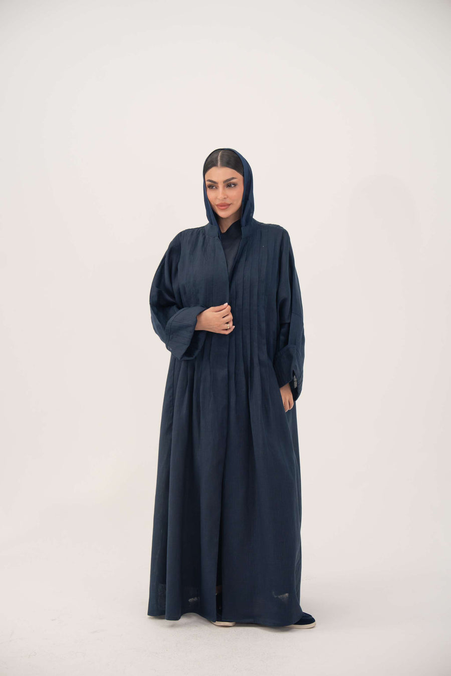 Woman wearing full-length open-front abaya navy blue linen with vertical stitched pleats