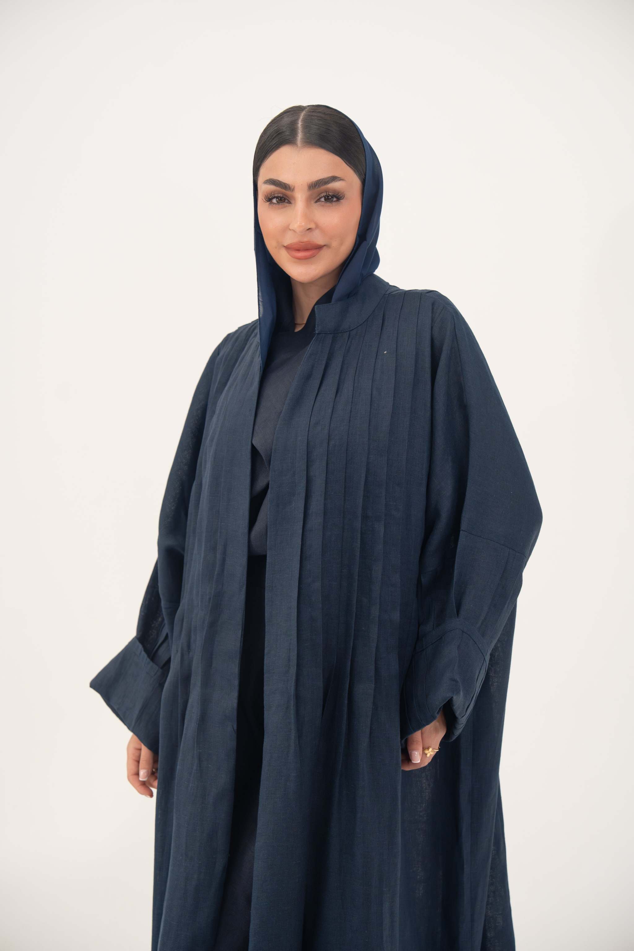 Woman wearing full-length open-front abaya navy blue linen with vertical stitched pleats
