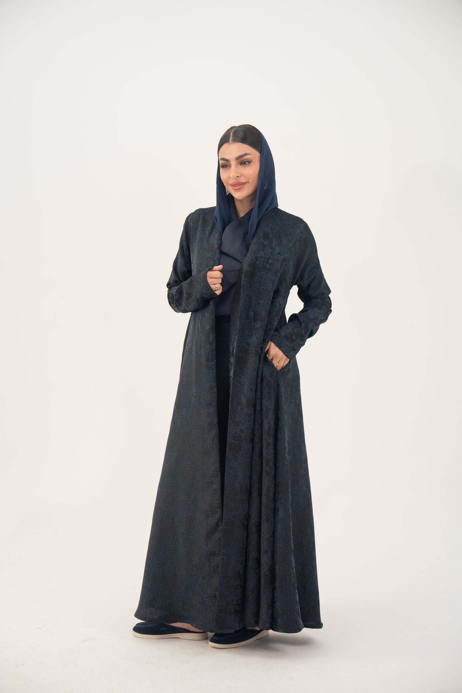 Elegant navy jacquard abaya with subtle textured pattern and soft shimmer, featuring a flowing cut for graceful drape and versatile wear.