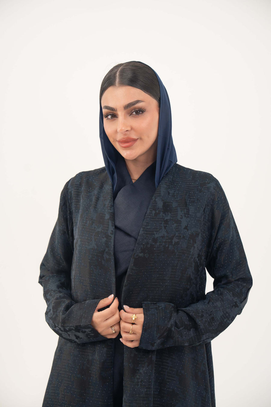 Woman wearing a navy jacquard abaya with subtle textured pattern and soft shimmer