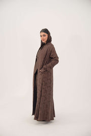 Full-length jacquard silk abaya in warm cocoa brown with subtle woven floral pattern and long sleeves.