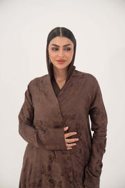 woman wearing a full-length relaxed A-line jacquard silk abaya with subtle floral pattern and long sleeves in warm cocoa brown