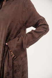 Jacquard silk Mercury abaya in warm cocoa brown with subtle floral pattern and long sleeves.