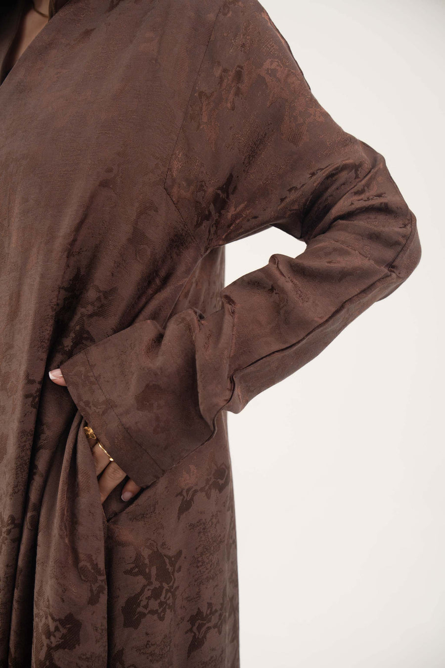 Jacquard silk Mercury abaya in warm cocoa brown with subtle floral pattern and long sleeves.