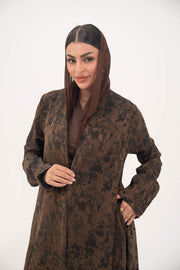 Woman wearing a lightweight espresso brown jacquard silk abaya with subtle tonal pattern, open front, side pockets, and full-length sleeves.