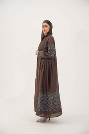 Mocha brown linen-blend abaya with blue embroidery panel on back and sleeves, batwing cut with blue piping, and light-blue cuff detail.