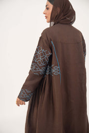 Mocha brown linen-blend abaya with sky-blue embroidery and batwing sleeves featuring blue piping and light-blue cuff details.
