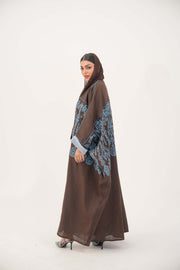 Brown Bisht abaya with intricate blue embroidery and rolled cuffs on wide sleeves.